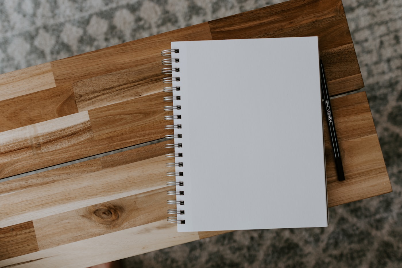 Caderno de espiral aberto e em branco sobre uma mesa de madeira