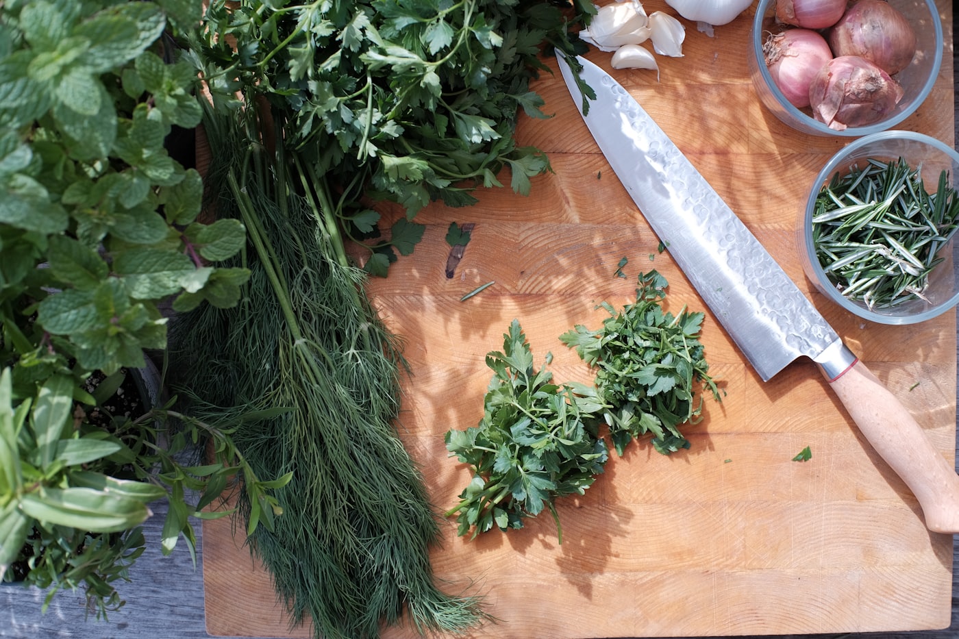 Ervas aromáticas frescas sobre uma tábua de madeira